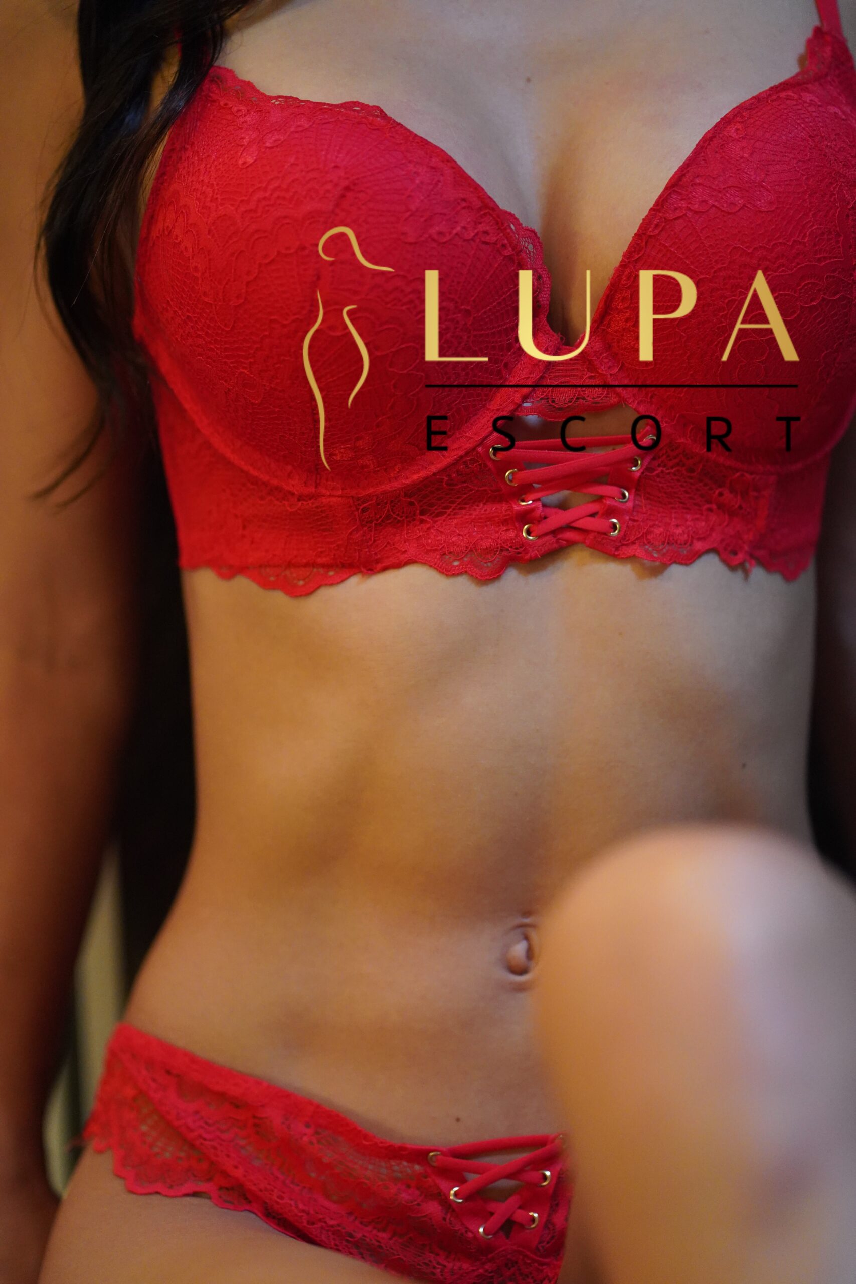 sexy alina in roten dessous auf der sessel kante steht eine stehlampe das licht strahlt ihre silouette seitlich im profil lupa escort